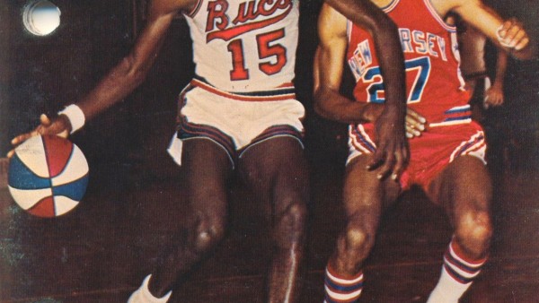 Two men playing basketball on a court.