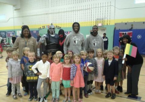 A group of children posing for a picture with a man in costume.