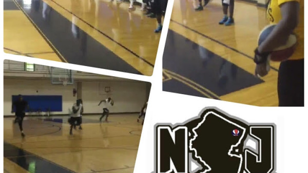 A group of people playing basketball in an indoor gym.