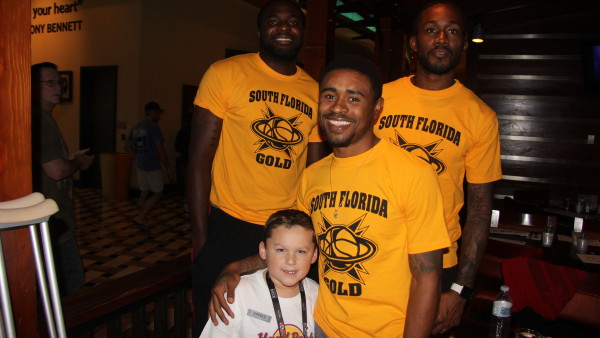 A group of men in yellow shirts posing for the camera.