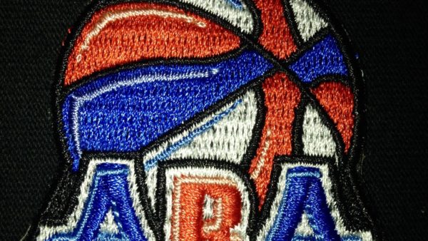 A close up of the aba logo on a black shirt.