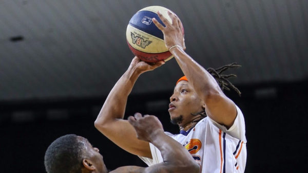 A basketball player is attempting to block the ball.