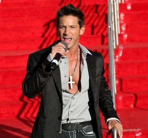 A man in black jacket holding a microphone.