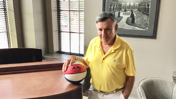 Man in yellow shirt holding basketball.